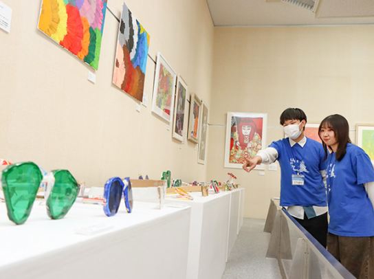 メガネやカラフルな絵が並ぶ会場＝岡崎市岡町で