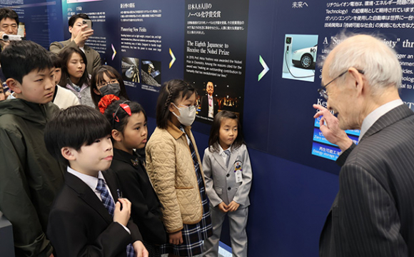 名城大の吉野終身教授の説明を聞く絵画展の受賞者ら＝名古屋市天白区の同大天白キャンパスで