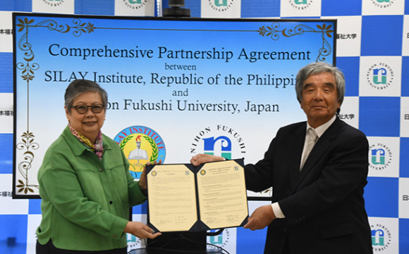 協定書に署名した丸山理事長（右）、レベンター学校長＝美浜町の日本福祉大で