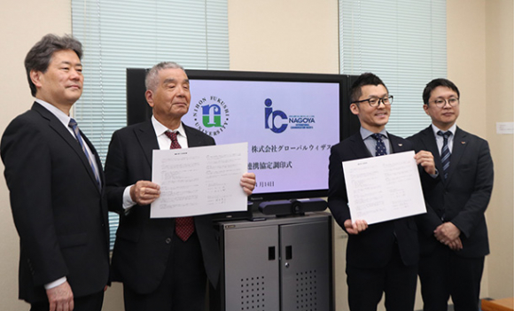 協定書を手にする丸山理事長（左から２人目）と鈴木社長（同３人目）＝名古屋市中区の日本福祉大名古屋キャンパスで