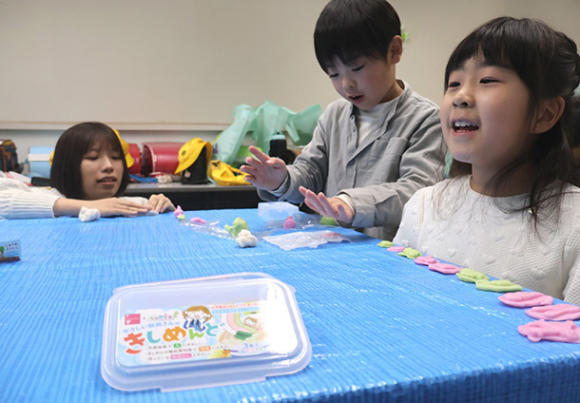 南山大の学生と一緒に粘土で遊ぶ児童＝愛知県豊山町の新栄小で
