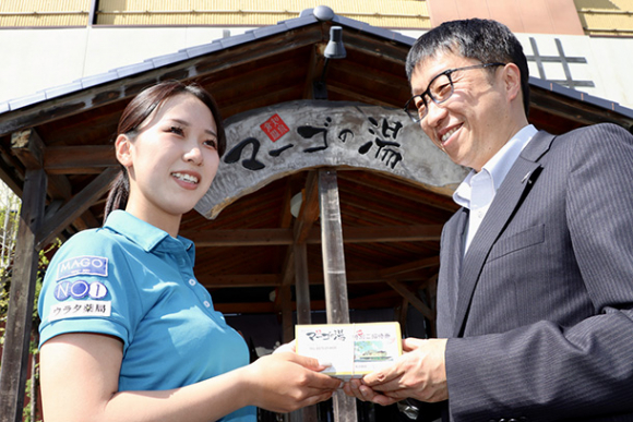 広瀬社長(右)から入浴券を受け取る女子主将=関市倉知のマーゴの湯で