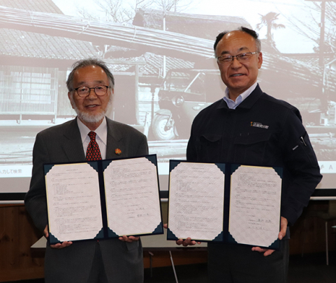 協定書を交わした佐分学長（左）と秦野社長＝小牧市の竹藤商店で