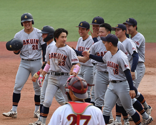 サヨナラ打を放った杉山（背番号２３）を迎える愛院大ナイン＝パロマ瑞穂球場で