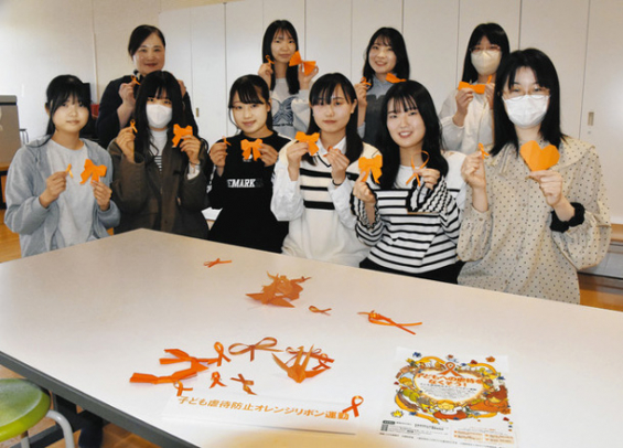 児童虐待防止を呼びかける上村教授（後列左）と学生たち＝名古屋市守山区の金城学院大で