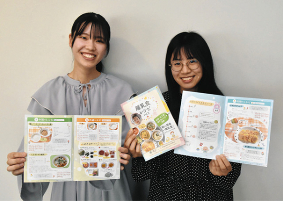 制作に携わったレシピ冊子を手にする山田さん（左）と神谷さん＝千種区の椙山女学園大で