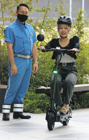 電動キックボードの乗車体験をする学生（右）ら＝中村区の愛知大名古屋キャンパスで