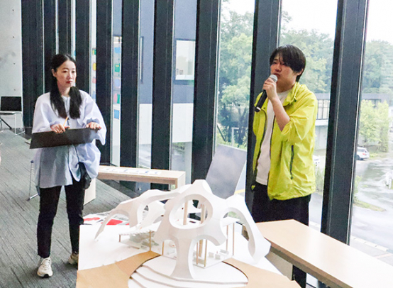 自ら設計した図書館の模型を前に説明する学生（右）＝長久手市の県立芸術大で