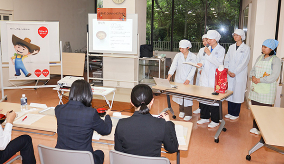 スジャータめいらくの審査員にレシピを説明する学生たち＝春日井市松本町の中部大で