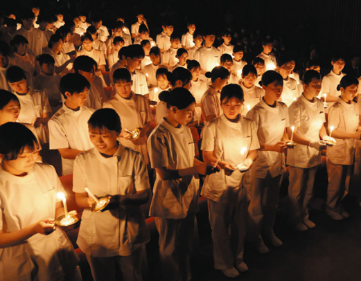 キャンドルに火をともす学生たち＝長久手市の愛知医科大で