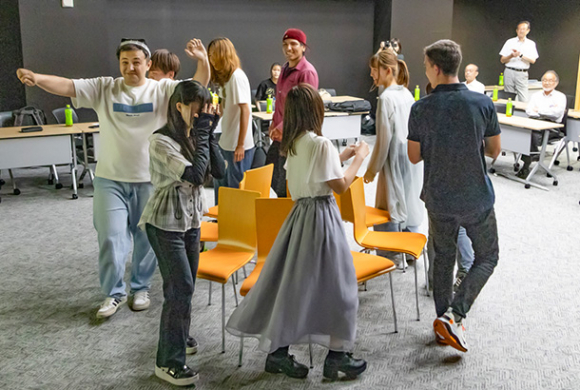 ウズベキスタンの音楽で、いす取りゲームを楽しむ学生たち＝犬山市の名古屋経済大で