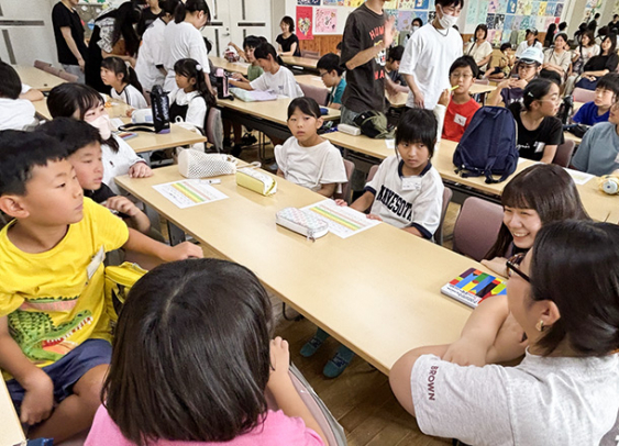 英語で自己紹介し合う大学生と小学生=各務原市の中部学院大各務原キャンパスで