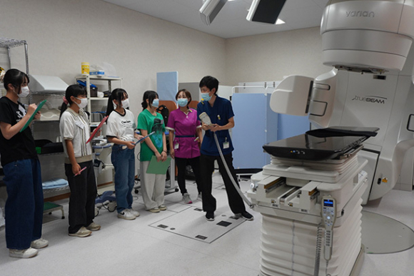 放射線治療装置の説明を受ける参加者たち＝関市若草通の中濃厚生病院で