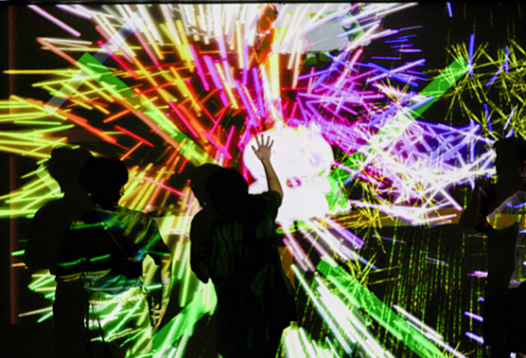 壁に触れて花火が映し出される様子を楽しむ人たち＝春日井市中央台のサンマルシェで