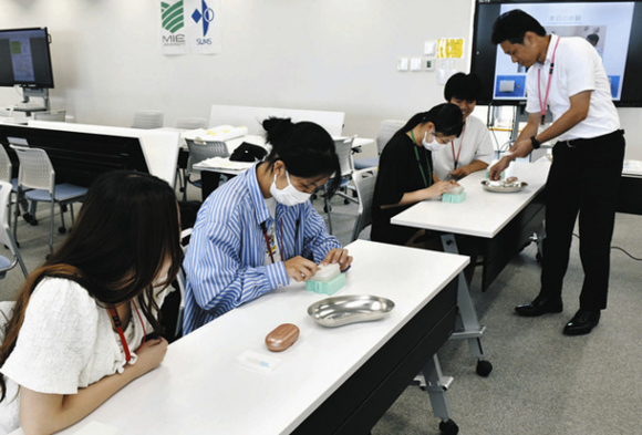 人体のつぼについて学ぶ学生ら＝鈴鹿市の鈴鹿医療科学大で