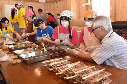 住民と一緒におはぎを作って交流する学生たち=石川県能登町で
