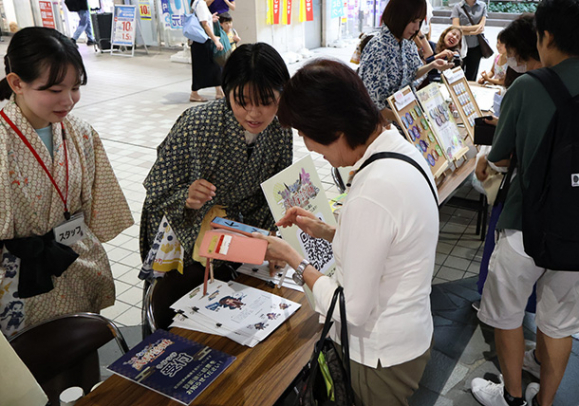 質問に答えると自分に似た武将が分かる診断を試す来場者=名東区の市営地下鉄上社駅前で