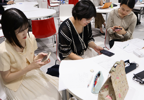 スマホで生成ＡＩとやりとりをする学生＝千種区の愛知淑徳大星が丘キャンパスで