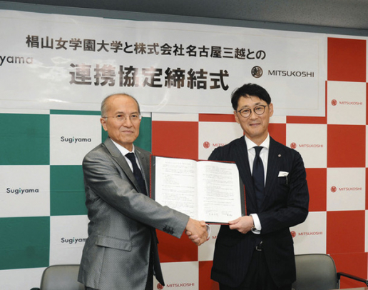 協定書に調印し、黒田学長（左）と握手する鈴木社長＝名古屋市千種区の椙山女学園大で