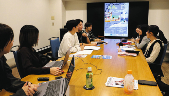 中日本興業の若手社員（左手前２人）に見守られながら映画祭に向けて話し合う学生たち＝中村区で