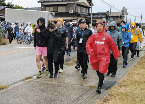 ２年ぶりの１００キロ歩行イベントに挑む学生たち。「復興祈願」を合言葉に半島を縦断した＝七尾市内で