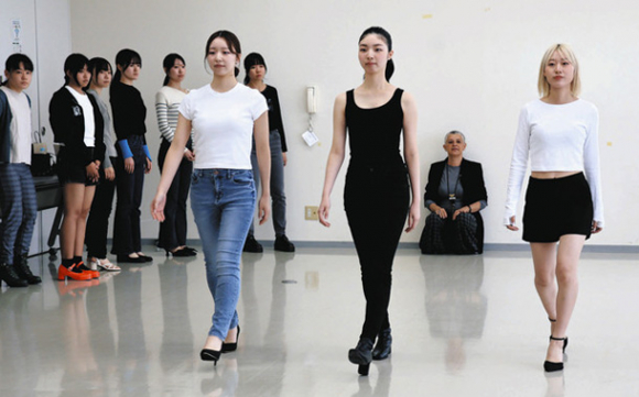 講師（後方）が見守る中、モデルの梨杏さん（手前右から２人目）を手本に歩き方を学ぶ参加者＝蒲郡市の蒲郡商工会議所で