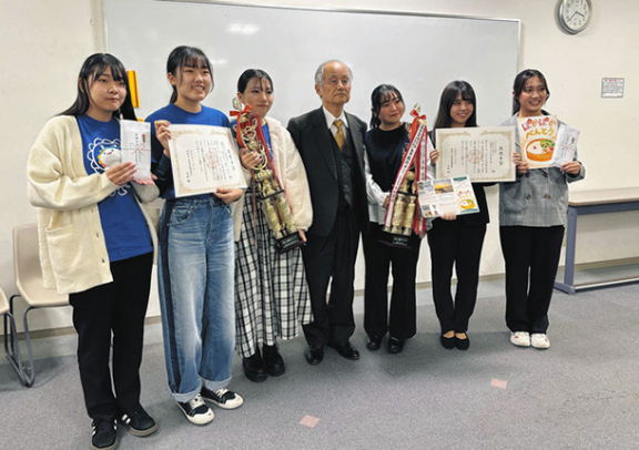 最優秀賞に選ばれた短大生活デザイン総合学科(左の3人)と、大学こどもの生活学科(右の3人)の発表者=岡崎市舳越町で