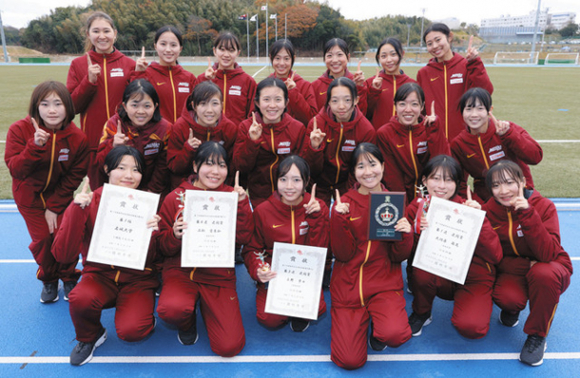 東海学生女子駅伝対校選手権大会で優勝し、記念写真に納まる名城大の選手ら＝美浜町運動公園陸上競技場で
