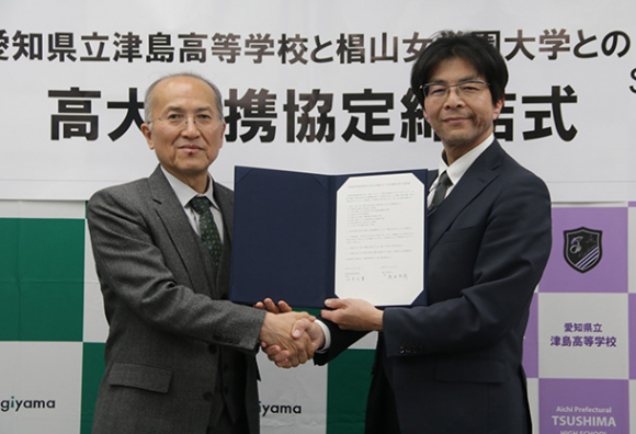 協定を締結して握手を交わす黒田学長（左）と川手校長＝名古屋市千種区の椙山女学園大で 