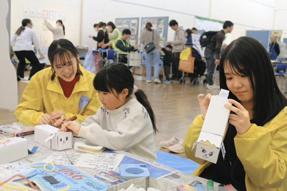 学生たちに教わりながら工作を楽しむ児童（中）＝豊明市文化会館で