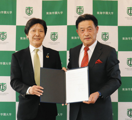 協定書を手にする石川学長(右)と井上執行役員=みよし市福谷町の東海学園大で(東海学園大提供)