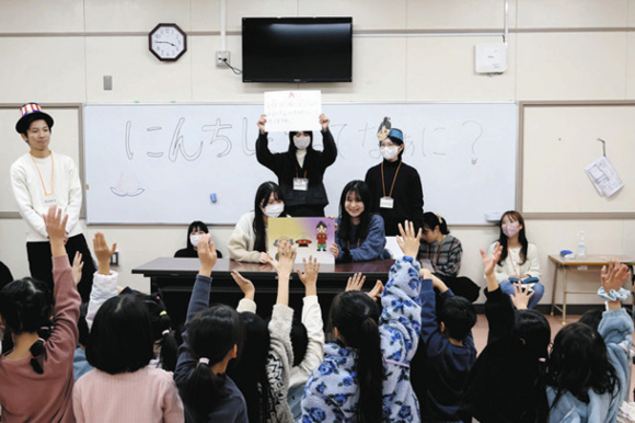 認知症について伝える紙芝居を児童に披露する愛知淑徳大の学生たち＝千種区の上野小で