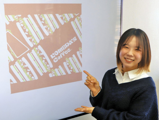 コメダの豆菓子の包装デザインに選ばれた作品を示す松岡遥優さん=名古屋市東区のコメダで