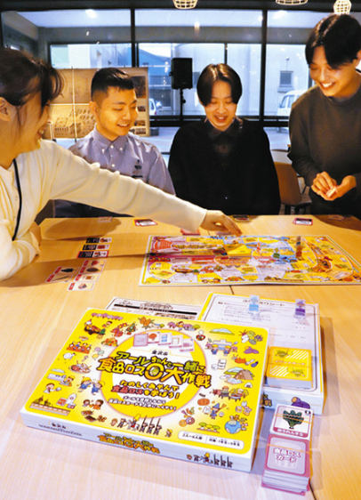 食品ロス削減すごろくをプレーし、仕上がりを確認する(右から)岡田隆希さん、吉田翼さん、片瀬環さんら=野々市市で