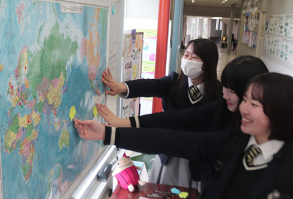 世界地図に付箋を貼り付ける生徒たち=昭和区の中京大中京高で