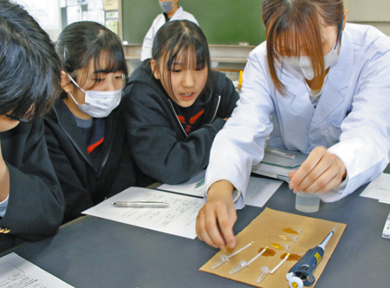学生（右）のサポートを受け、実験する生徒たち＝金沢市高尾台中で