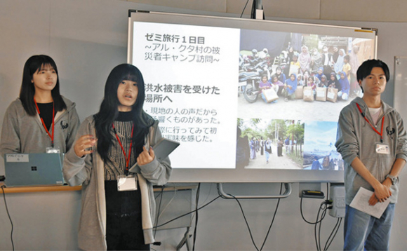 スライドを使い、洪水被害を受けたインドネシアの被災地について語る学生たち=熱田区の名古屋学院大で