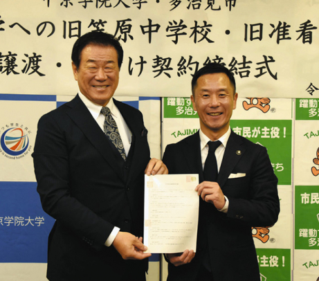 契約書に署名した中谷理事長（左）と高木市長＝多治見市役所で