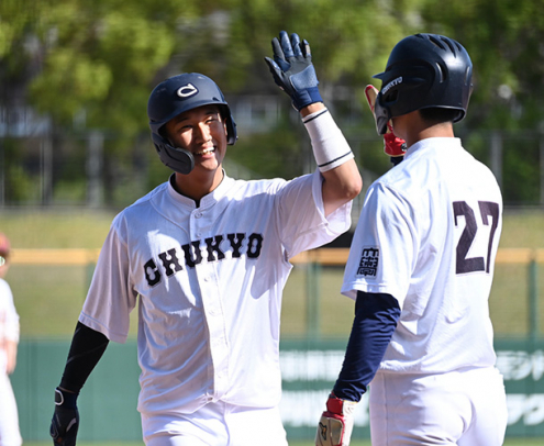 名城大－中京大　タイブレークの１０回に勝ち越しの３ランを放ち、仲間とハイタッチする中京大の狩俣（左）＝パロマ瑞穂球場で（石曽根和花撮影）
