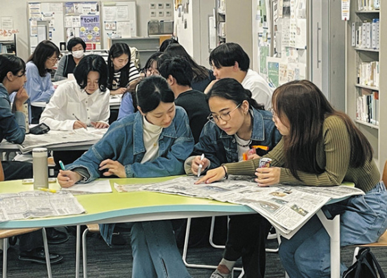 中日新聞朝刊を読み、疑問点などを話し合う学生ら＝名古屋市昭和区の南山大で