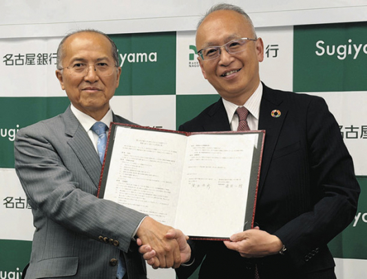 協定書を手に握手する椙山女学園大の黒田学長(左)と名古屋銀の藤原頭取=千種区の椙山女学園大で