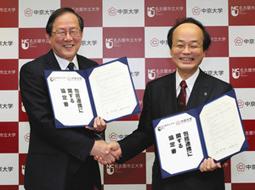 包括連携協定を締結し握手する中京大の安村学長（左）と名古屋市立大の郡学長＝昭和区の中京大で