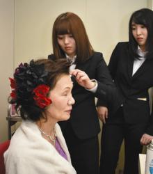 化粧直しをする学生＝関市の中部学院大関キャンパスで