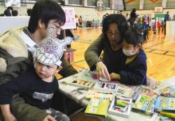 お面の色塗りを楽しむ家族連れ=大垣市西之川町の大垣女子短大で