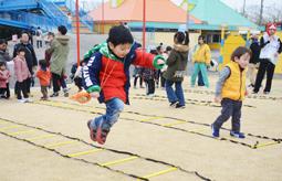 日本福祉大の学生から教わりながらロープのはしごの上を走る子ども＝美浜町の南知多おもちゃ王国で