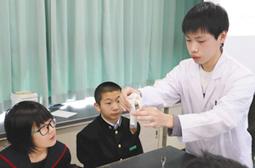 金沢工業大の学生(右)から消化酵素「タカヂアスターゼ」の働きを学ぶ生徒=金沢市高尾台中で