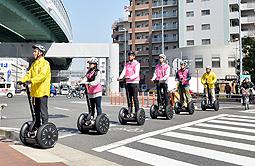 セグウェイに乗り、横断歩道を渡る名古屋学院大生ら=名古屋市熱田区で