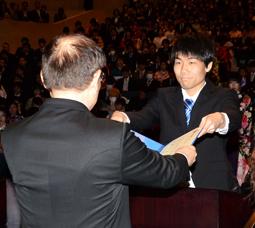 看護学部初の卒業生も臨んだ式典で、学位記を受ける看護学科代表の森本さん(右)=鈴鹿市の鈴鹿医療科学大で