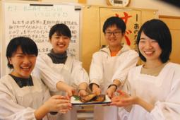 試作したサバ煮を手にする学生たち=岐阜県恵那市岩村町で