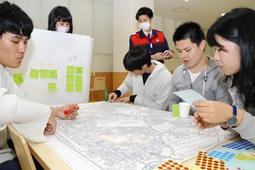 避難先や物資の調達先などを地図で確認する学生たち＝鈴鹿市の鈴鹿医療科学大で